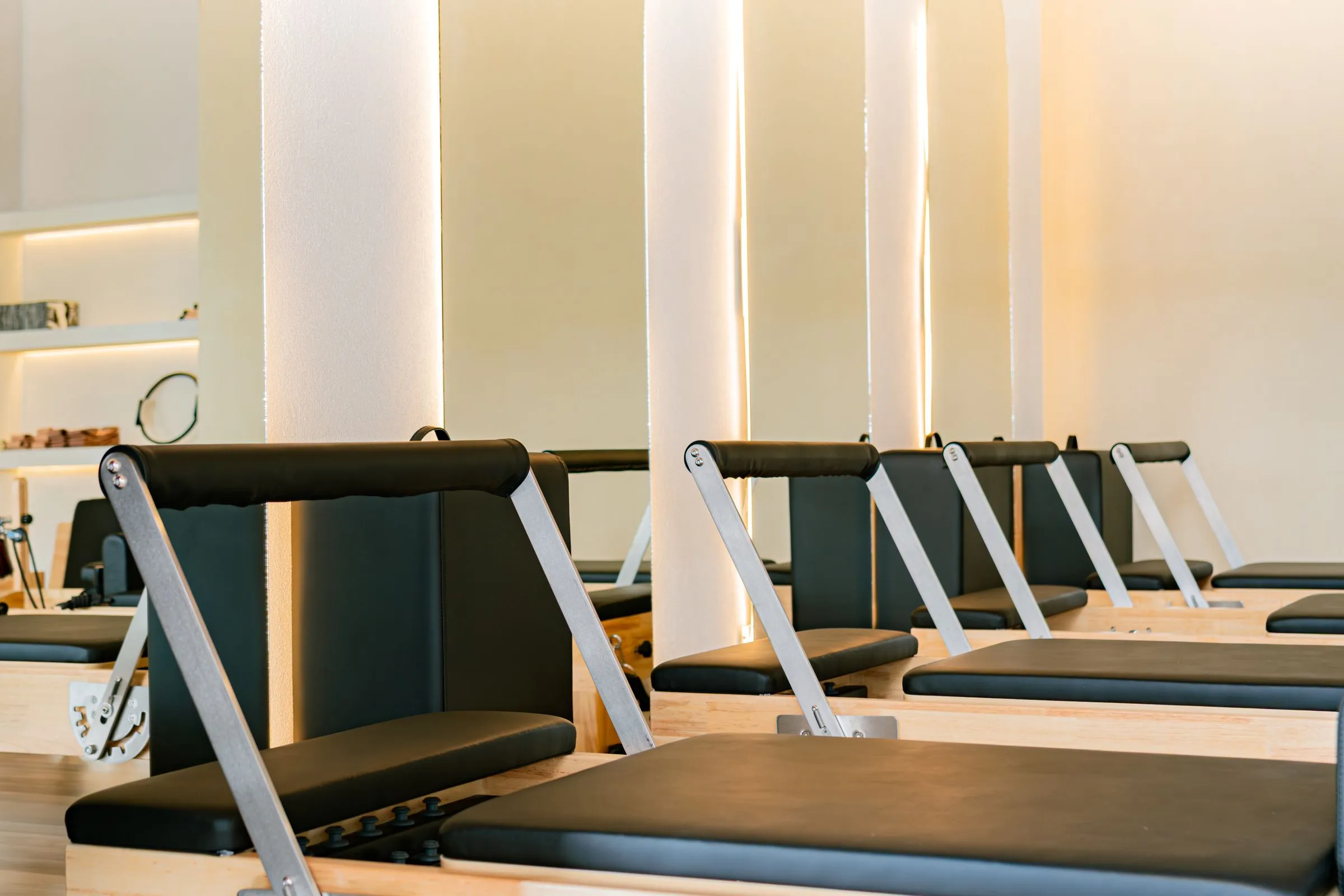 A row of reformer beds in a warm, minimalist studio