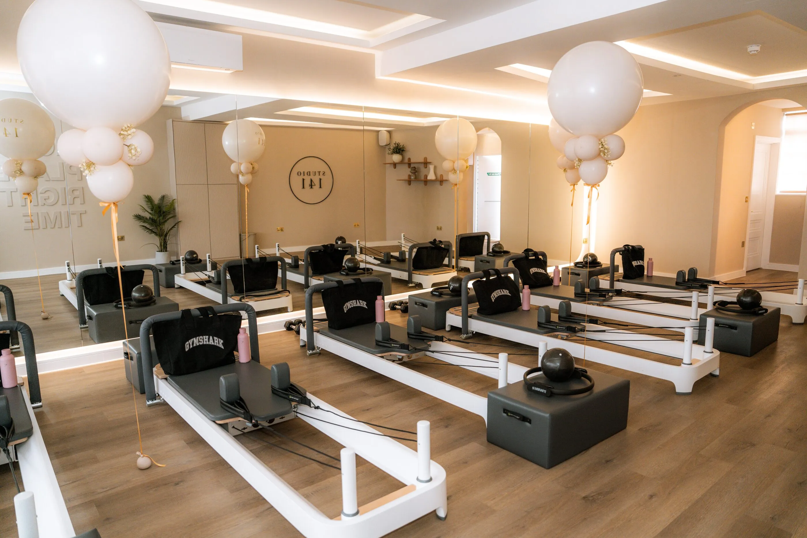 The Studio 141 reformer room: a row of Allegro 2 reformers under soft, warm lighting